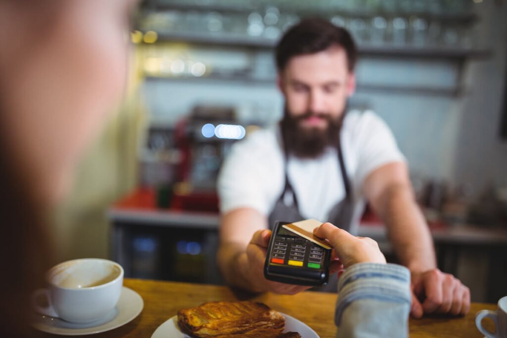 Un paiement par carte bancaire en cours sur un terminal de paiement chez un commerçant.