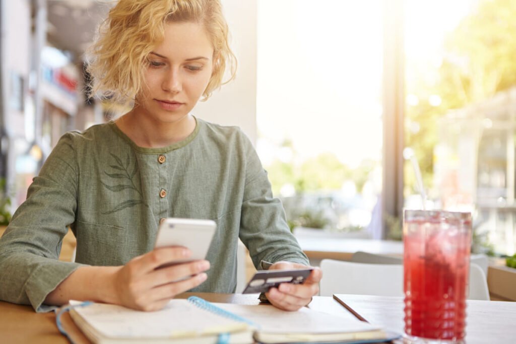 Un client consultant le solde de ses comptes sur l'application de sa banque sur son smartphone.