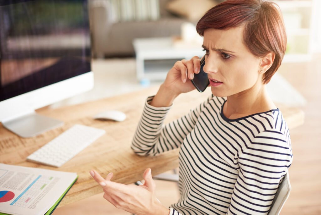 Un client appelant son conseiller bancaire au téléphone pour bloquer des frais automatiques.