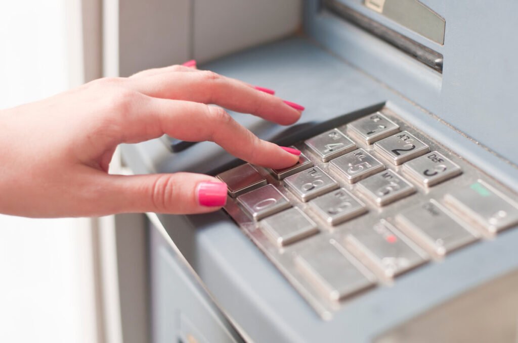 Une personne glissant un chèque de paiement dans la boîte aux lettres de dépôt d'une agence bancaire.