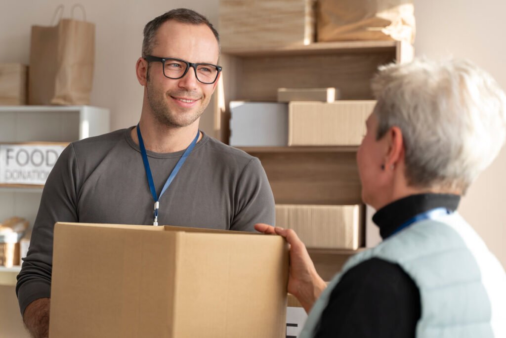 Un client déposant un carton d'envoi auprès d'un guichet de commerçant partenaire.